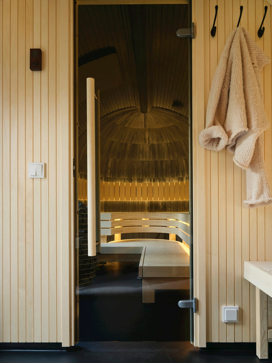 A bathroom with a bench and towels hanging on the wall